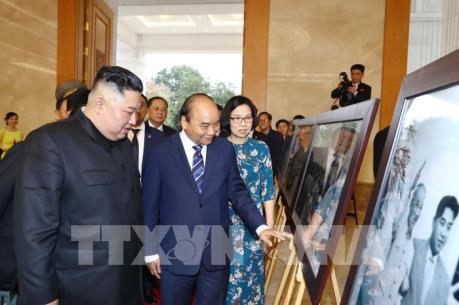 Thủ tướng Nguyễn Xuân Phúc và Chủ tịch Kim Jong-un tham quan trưng bày ảnh của TTXVN