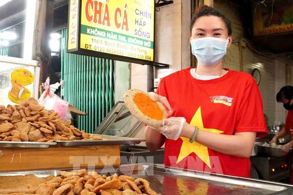 Tiểu thương Đà Nẵng thể hiện quyết tâm chiến thắng COVID-19 với áo mang hình cờ Tổ quốc