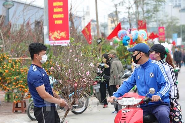 Người dân Hà Nội áp dụng các biện pháp phòng, chống dịch COVID-19 tại chợ hoa Tết