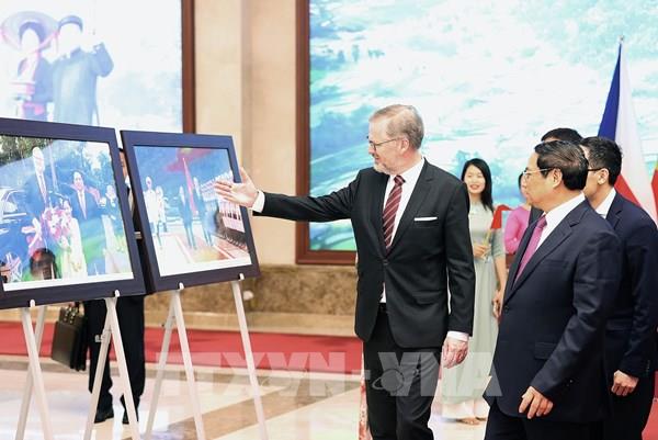Thủ tướng Phạm Minh Chính và Thủ tướng Séc Petr Fiala tham quan trưng bày ảnh của TTXVN