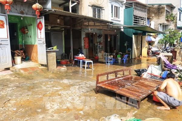 Hình ảnh người dân ngoài bãi sông Hồng dọn dẹp nhà cửa sau khi nước rút